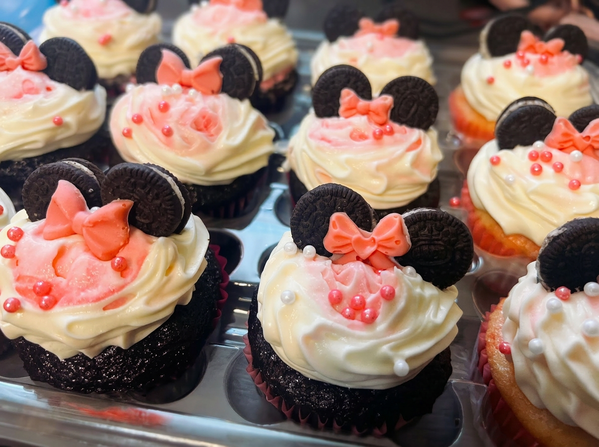 Decorated cupcakes with pink frosting and cookie toppers