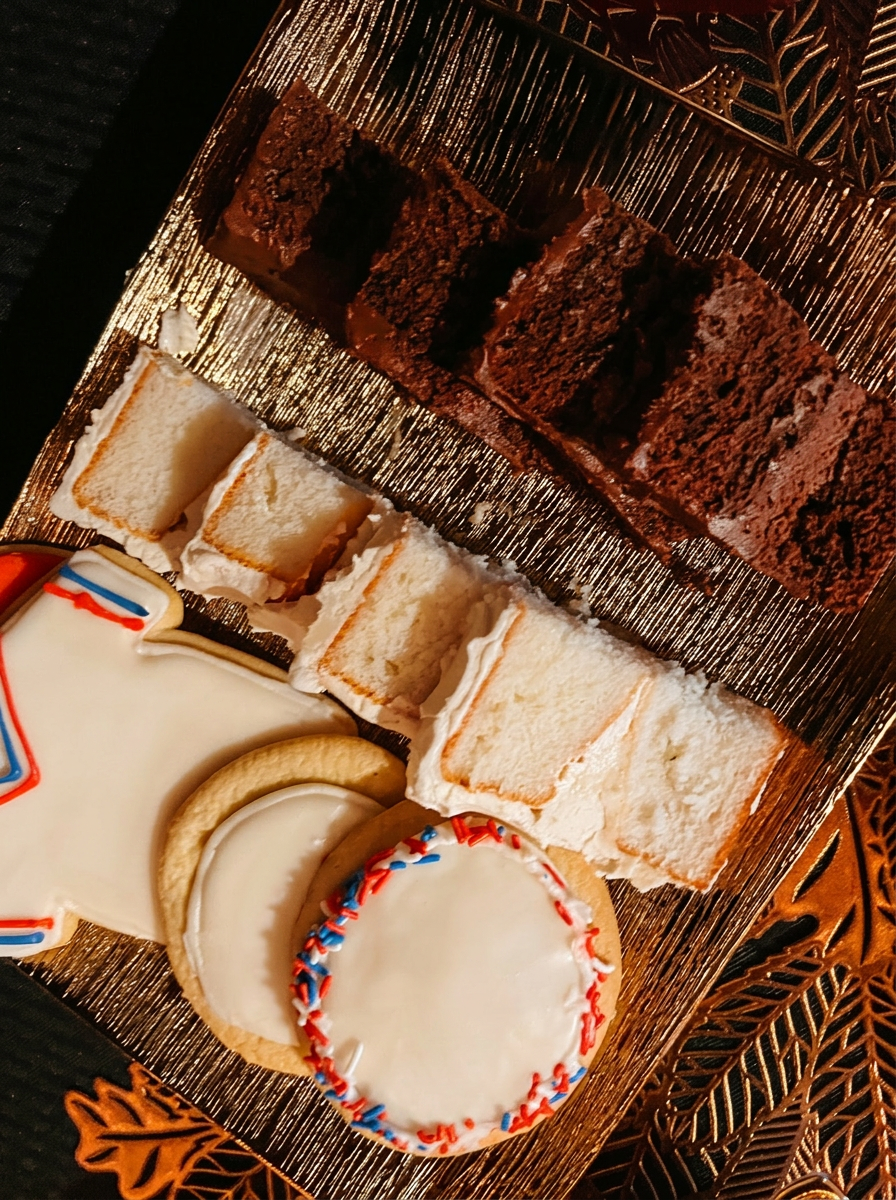 Handmade cake bites and decorated cookies on a dessert tray